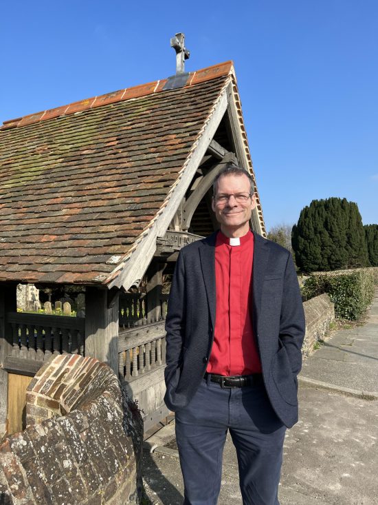 Vicar standing in front of lychgate